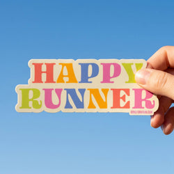 Colorful 'Happy Runner' sticker held against a blue sky