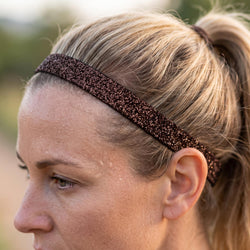 Close-up of a person wearing a glittery brown headband outdoors.