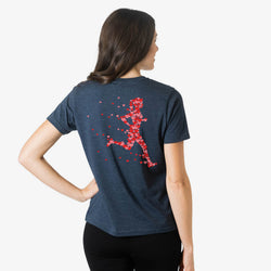 Woman wearing a blue t-shirt with a red  heart running person design on the back, on a white background