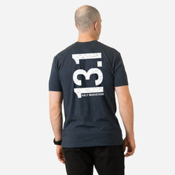 Person wearing a navy blue t-shirt with '13.1 Half Marathon' printed on the back against a white background