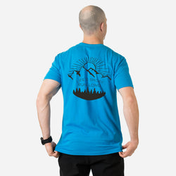 Person wearing a blue t-shirt with a mountain graphic and text on the back, on a white background