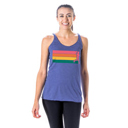 A woman modeling a heathered blue racerback tank top with a graphic of a runner followed with horizontal rainbow stripes, set against a plain white background.