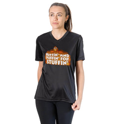 A woman modeling a black V-neck athletic t-shirt with a cartoon turkey graphic and the text 'HUFFIN' AND RUFFIN' FOR STUFFIN'' in orange, yellow, and white, paired with black leggings against a plain white background.