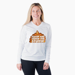 A woman modeling a white long-sleeve V-neck athletic shirt with a graphic on the chest that reads 'Huffin' and Puffin' for Stuffin'' with cartoon turkey illustration, against a plain white background.