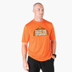 A man wearing a bright orange athletic t-shirt with a graphic of a turkey and the text 'HUFFIN' AND PUFFIN' FOR STUFFIN''.