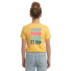 Person wearing a yellow t-shirt with colorful volleyball text on the back, standing against a white background