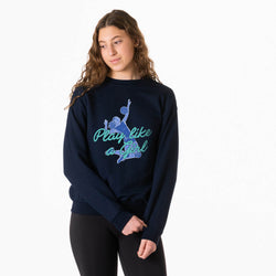 A woman modeling a navy blue crewneck sweatshirt with a graphic of a volleyball player and the text 'Play like a Girl' in teal and light blue, set against a plain white background.