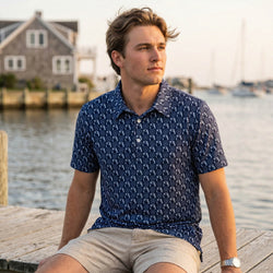 Teen wearing a blue soccer patterned polo shirt sitting on a dock by water
