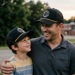 Man and young boy wearing matching wrestling caps outdoors