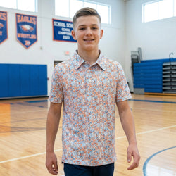 Young man in a wrestling patterned polo shirt standing in a gymnasium